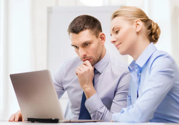 Serious business couple with laptop computer — Stock Photo, Image