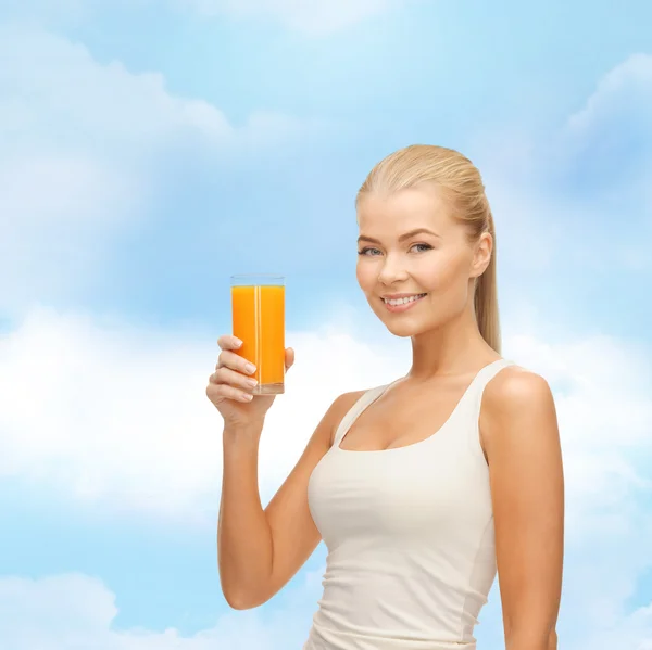 Mulher sorridente segurando vidro de suco de laranja — Fotografia de Stock