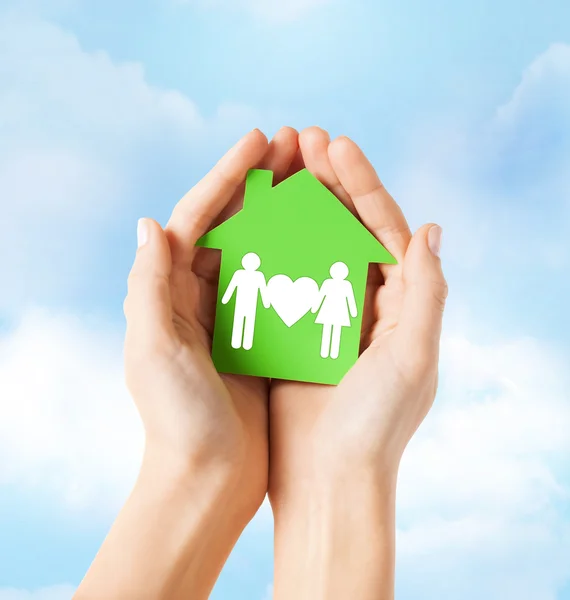 Mani che tengono casa verde con la famiglia — Foto Stock