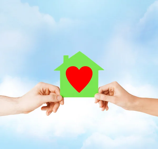 Couple hands holding green paper house — Stock Photo, Image