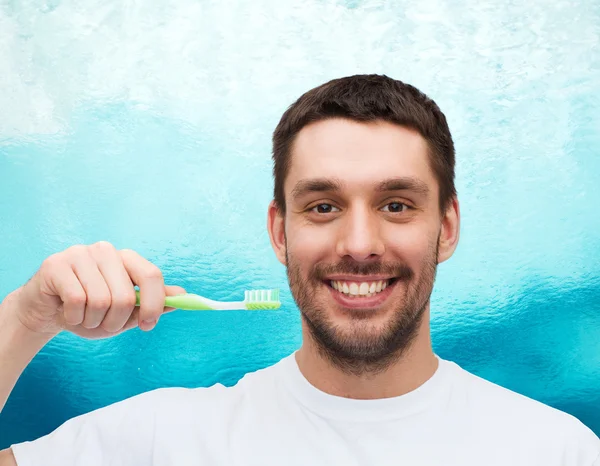 Усміхнений молодий чоловік з зубною щіткою — стокове фото