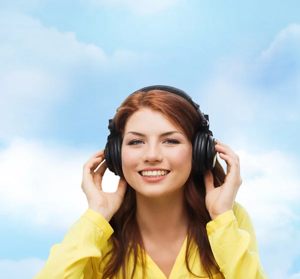 Sonriente chica joven en los auriculares en casa —  Fotos de Stock