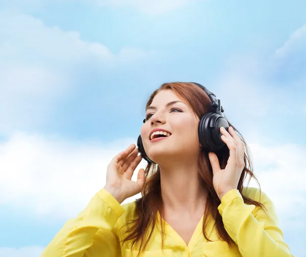 Smiling young girl in headphones at home — Stock Photo, Image