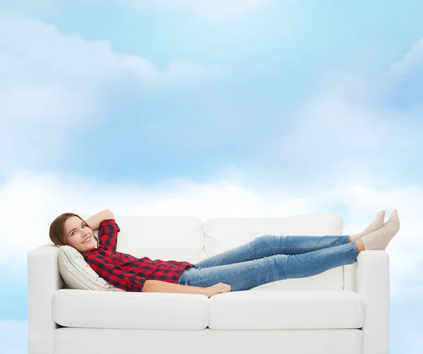 Smiling teenage girl lying on sofa — Stock Photo, Image