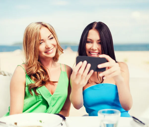 Les filles prennent des photos dans un café sur la plage — Photo