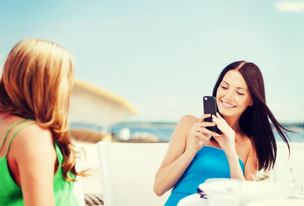 Tjejer tar foto i café på stranden — Stockfoto