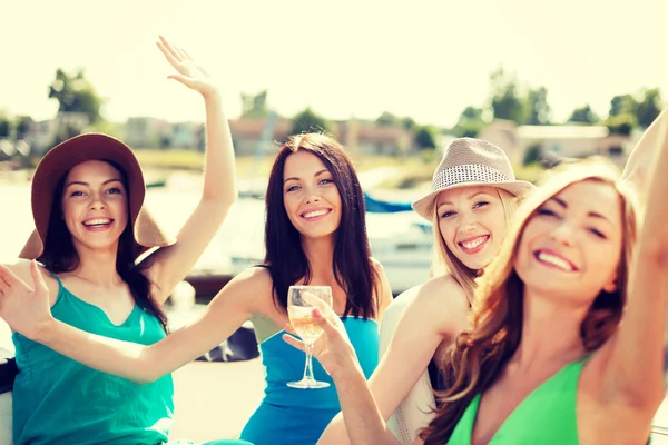Meisjes met champagneglazen op boot — Stockfoto