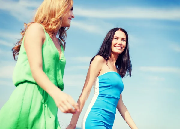 Meisjes lopen op het strand — Stockfoto