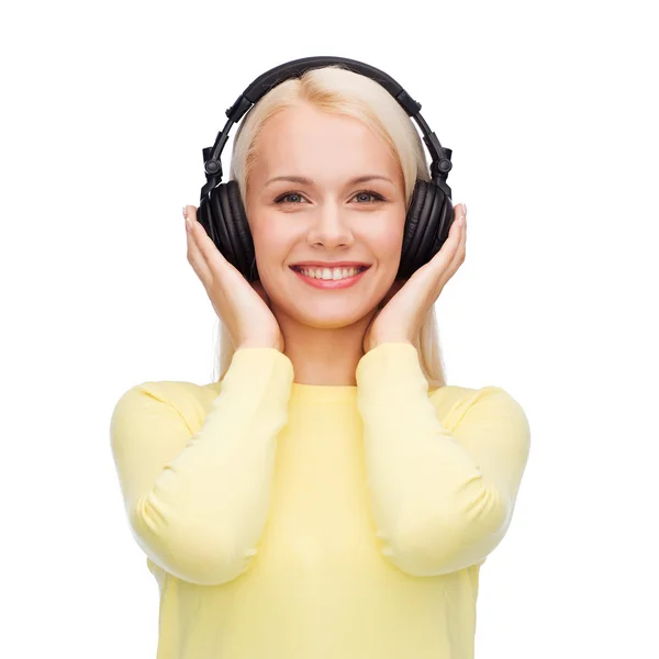 Leende ung kvinna med hörlurar — Stockfoto