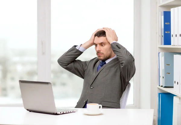 Upptagen affärsman med laptop och kaffe — Stockfoto