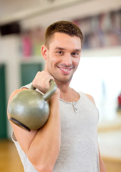 Sorrindo homem com kettlebell no ginásio — Fotografia de Stock