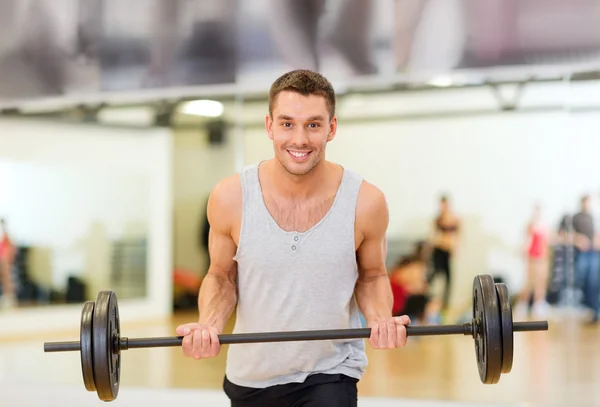 Sorrindo homem com barbell no ginásio — Fotografia de Stock