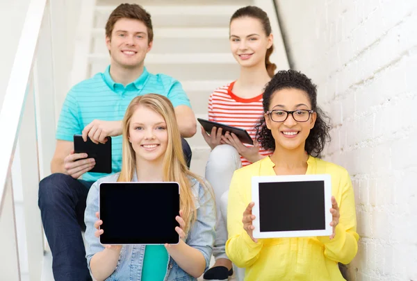 Estudantes sorrindo mostrando tablet pc tela em branco — Fotografia de Stock