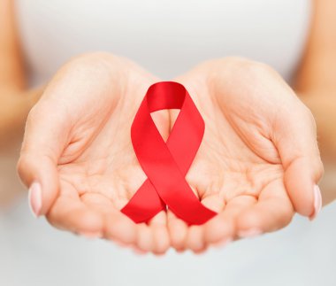 hands holding red AIDS awareness ribbon clipart
