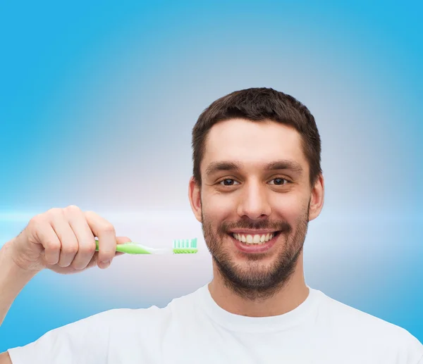 用牙刷的年轻男人微笑着 — 图库照片