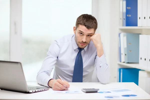 Homem de negócios estressado com laptop e documentos — Fotografia de Stock