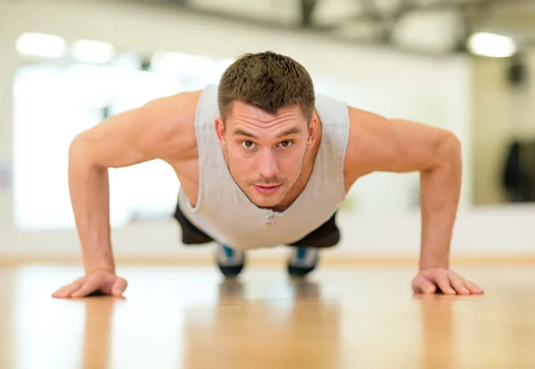 Homem concentrado fazendo flexões no ginásio — Fotografia de Stock