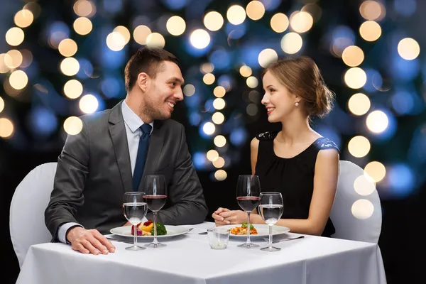 smiling couple eating main course at restaurant