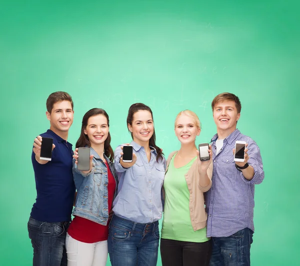 Estudantes mostrando telas de smartphones em branco — Fotografia de Stock