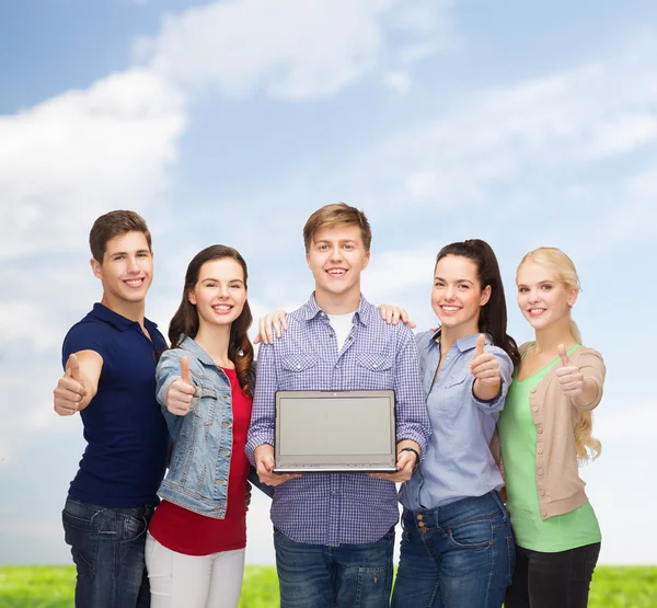 Estudiantes sonrientes con computadora portátil — Foto de Stock