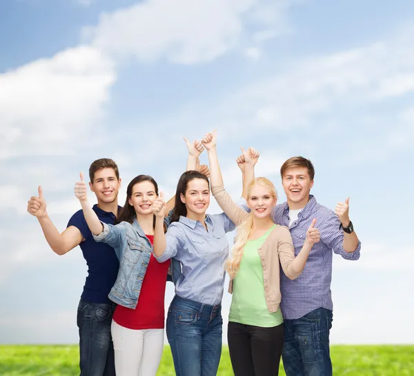 Groep lachende studenten tonen duimen omhoog — Stockfoto