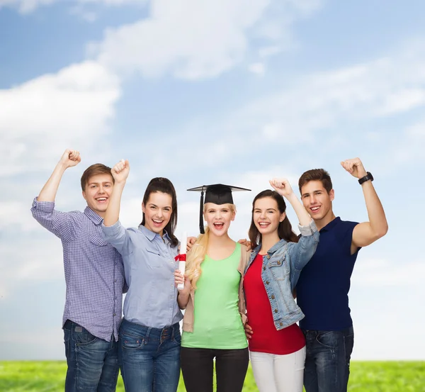 Grupo de estudiantes sonrientes de pie con diploma —  Fotos de Stock