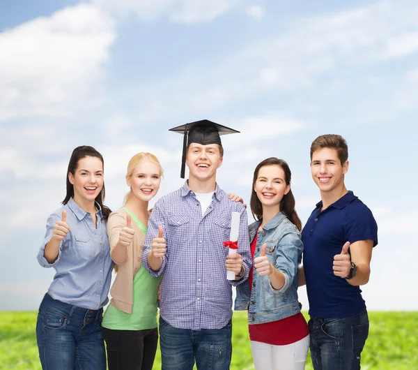 Grupo de estudiantes con diploma mostrando pulgares hacia arriba —  Fotos de Stock