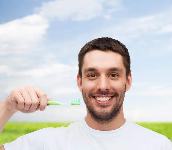 Joven sonriente con cepillo de dientes — Foto de Stock