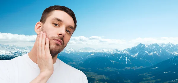 Belo homem calmo tocando seu rosto — Fotografia de Stock