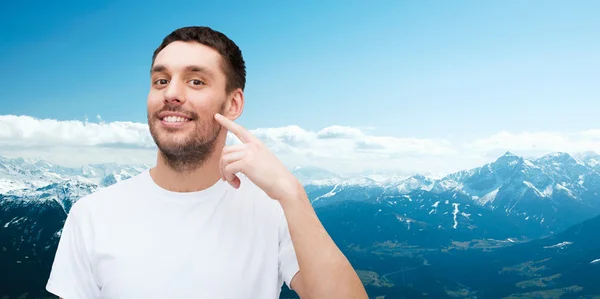 Sorrindo jovem bonito homem apontando para bochecha — Fotografia de Stock