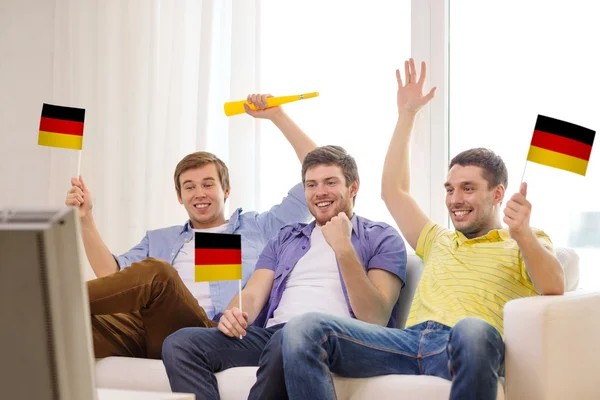 Happy male friends with flags and vuvuzela — Stock Photo, Image