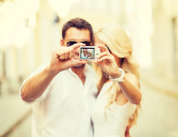 Casal viajante tirando foto com câmera — Fotografia de Stock