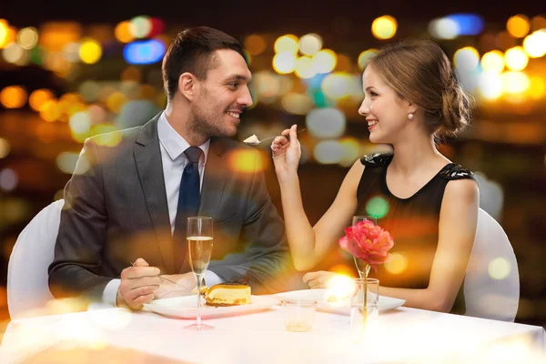 Pareja sonriente comiendo postre en el restaurante Fotos de stock libres de derechos