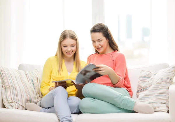 Two girlfriends reading magazine at home — Stock Photo, Image