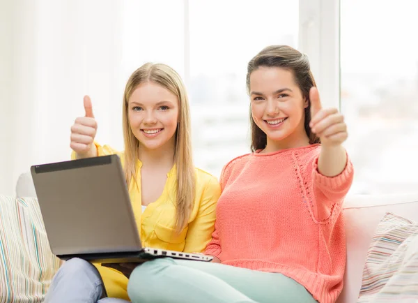 Duas meninas adolescentes sorridentes com laptop em casa — Fotografia de Stock