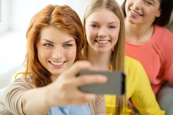 Chicas adolescentes sonrientes con teléfono inteligente en casa —  Fotos de Stock