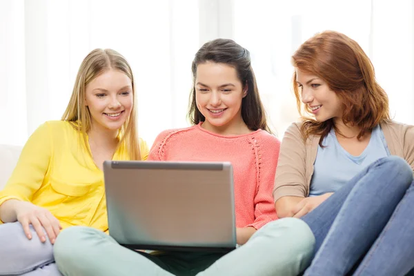 Tres niñas adolescentes sonrientes con ordenador portátil en casa —  Fotos de Stock