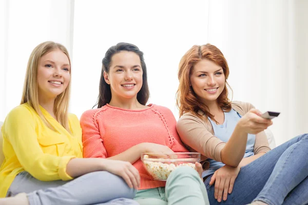 Tre sorridente ragazza adolescente guardando la tv a casa — Foto Stock