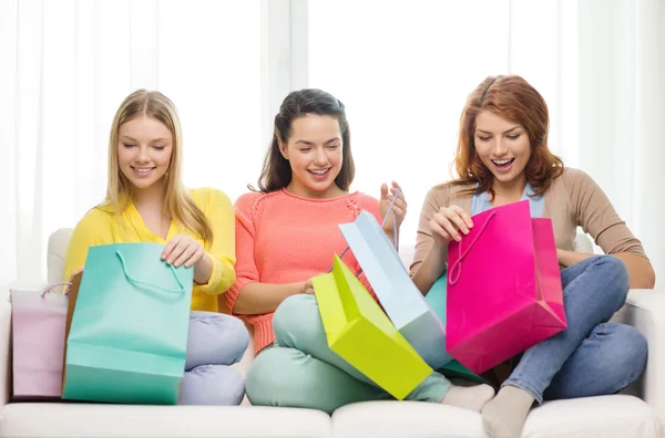 Lachende tienermeisjes met veel shopping tassen — Stockfoto