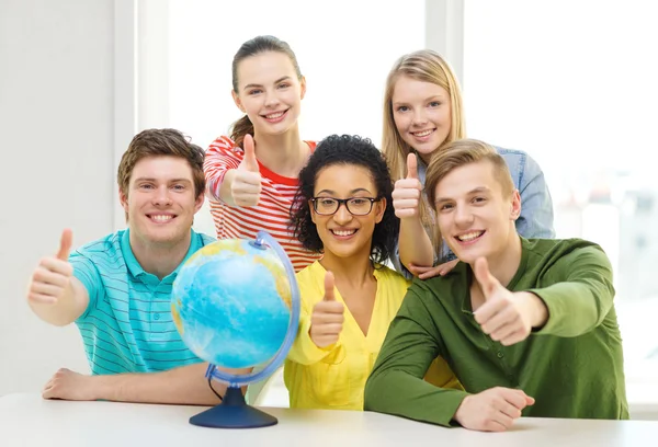 Cinco estudiantes sonrientes con globo terráqueo en la escuela — Foto de Stock