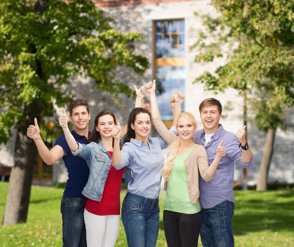 Gruppe lächelnder Studenten zeigt Daumen hoch — Stockfoto