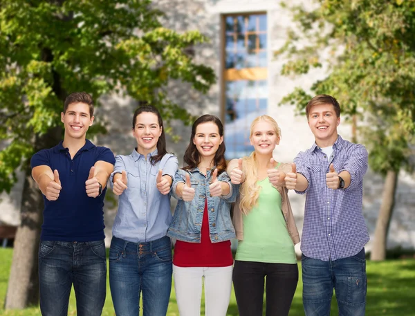 Grupp leende studenter visar tummen — Stockfoto