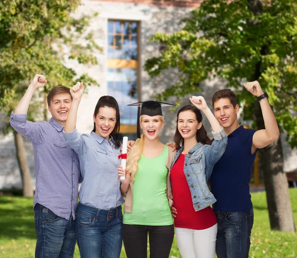 Grupo de estudiantes sonrientes de pie con diploma — Foto de Stock