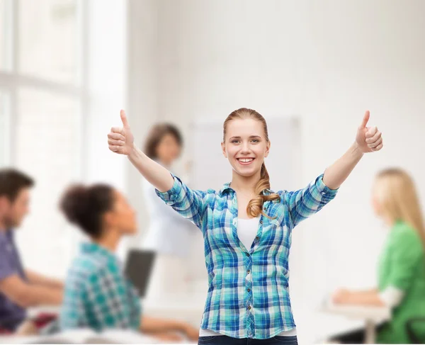 Smiling girl in casual clothes showing thumbs up — Stock Photo, Image