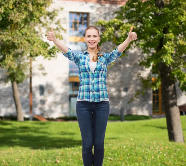 Menina sorridente em roupas casuais mostrando polegares para cima — Fotografia de Stock