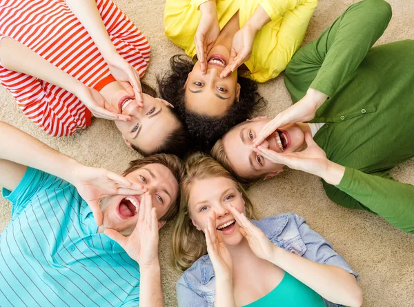 Sonriendo a la gente acostada en el suelo y gritando — Foto de Stock