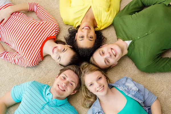 Group of smiling people lying down on floor Royalty Free Stock Photos