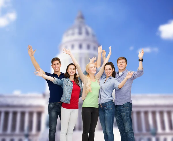 Group of smiling students waving hands — Stock Photo, Image
