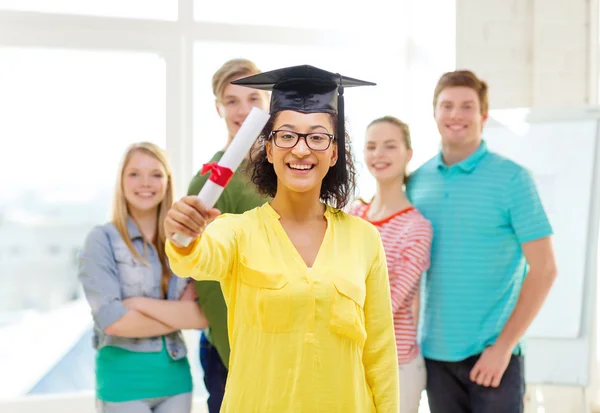 Estudante do sexo feminino sorridente com diploma e tampa de canto — Fotografia de Stock