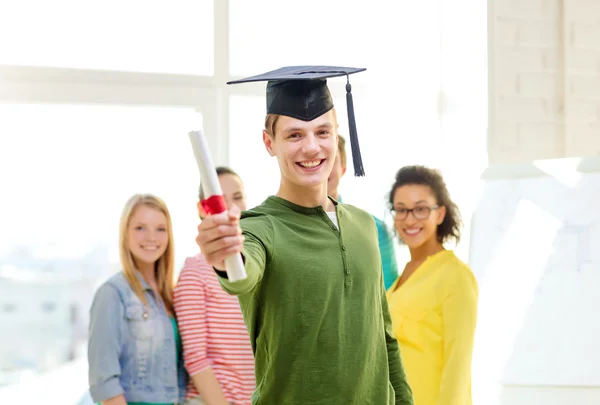 Estudiante masculino sonriente con diploma y gorra de esquina — Foto de Stock